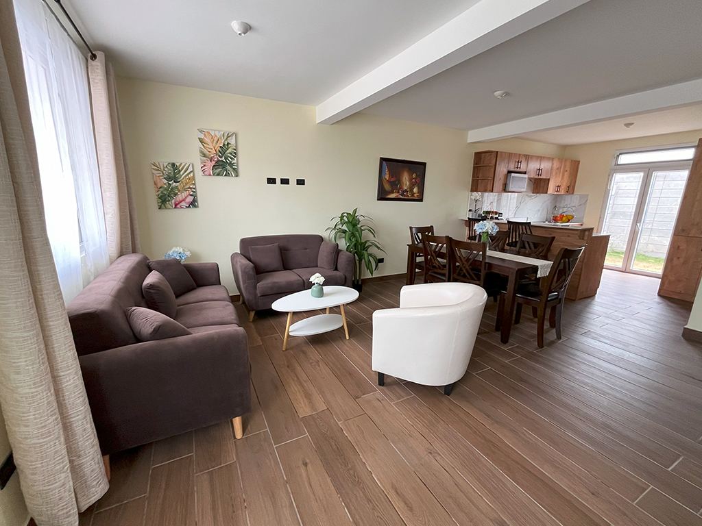 Sala, comedor y cocina de concepto abierto con piso tipo madera