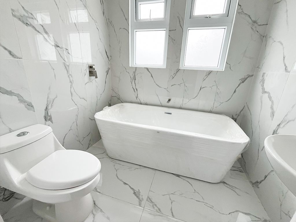 Baño con paredes y piso de porcelanato tipo mármol y tina independiente