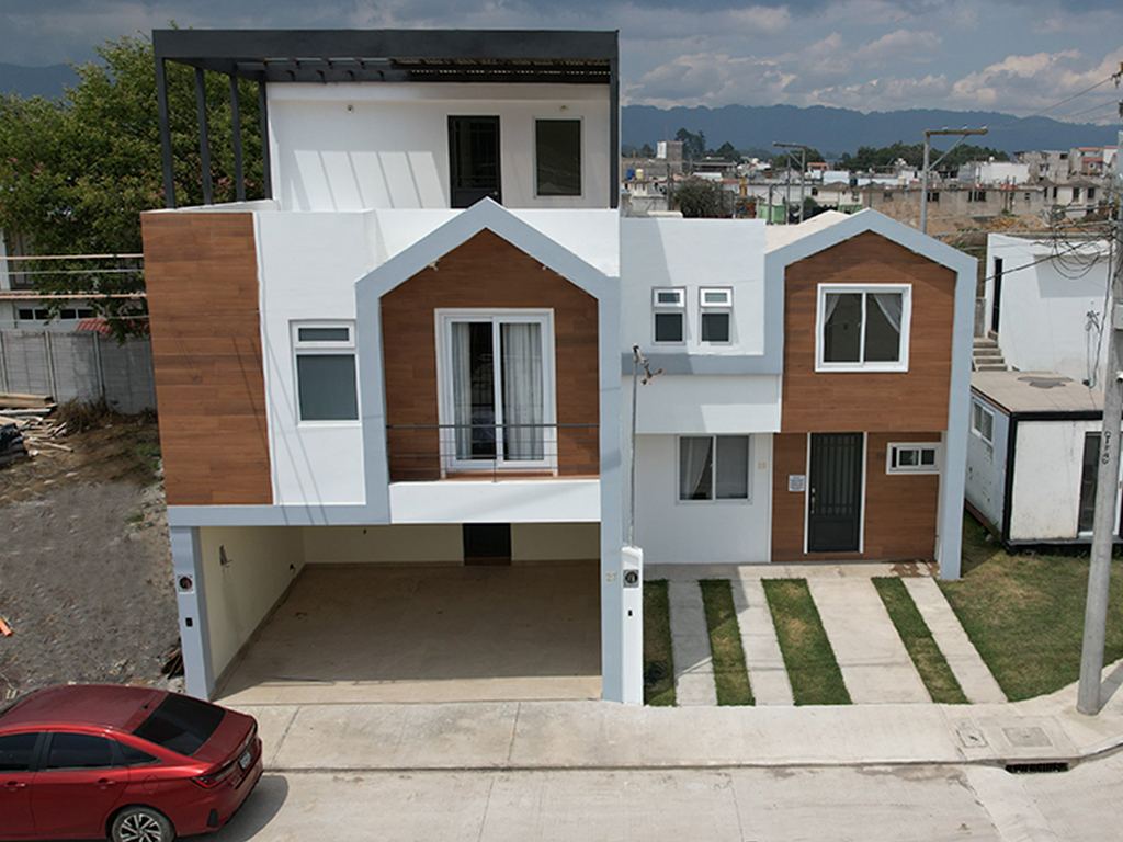 Casa de tres niveles con garaje techado y terraza superior